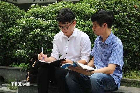 Đỗ Đức Mạnh được thày Phạm Đình Hiệp (phải) đồng hành trong hoạt động học tập. (Ảnh: Thanh Thương/TTXVN)