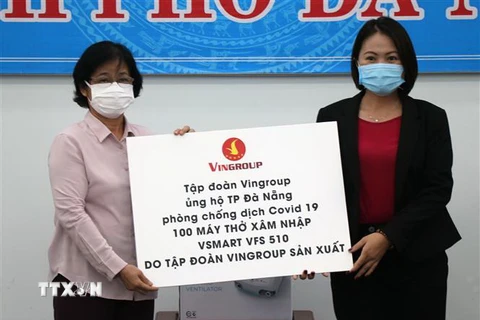 Chủ tịch Ủy ban Mặt trận Tổ quốc Việt Nam thành phố Đà Nẵng Đặng Thị Kim Liên (bên trái) nhận ủng hộ của đại diện Tập đoàn Vingroup. (Ảnh: Quốc Dũng/TTXVN)