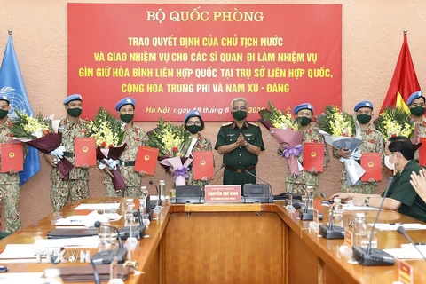 Thượng tướng Nguyễn Chí Vịnh, Thứ trưởng Bộ Quốc phòng trao Quyết định của Chủ tịch nước cho các sỹ quan đi làm nhiệm vụ gìn giữ hòa bình Liên hợp quốc. (Ảnh: Dương Giang/TTXVN)