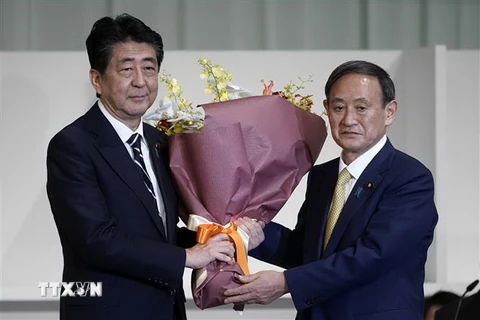 Thủ tướng Nhật Bản sắp mãn nhiệm Shinzo Abe (trái) chúc mừng tân Chủ tịch đảng Dân chủ Tự do (LDP) cầm quyền vừa đắc cử Yoshihide Suga tại Tokyo ngày 14/9/2020. (Ảnh: TTXVN phát)
