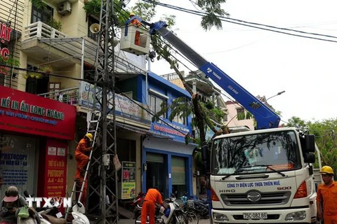 Công nhân đang sửa chữa điện tại thành phố Huế. (Ảnh: Tường Vi/TTXVN)