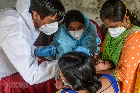 Nhân viên y tế lấy mẫu xét nghiệm COVID-19 tại Mumbai, Ấn Độ. (Ảnh: AFP/TTXVN)