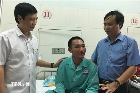 Chủ tịch UBND tỉnh Quảng Trị Võ Văn Hưng (áo xanh) thăm hỏi, tặng quà các thuyền viên và ngư dân bị nạn. (Ảnh: Hồ Cầu/TTXVN)