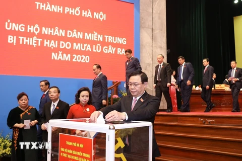 Ông Vương Đình Huệ, Ủy viên Bộ Chính trị, Bí thư Thành ủy, Trưởng đoàn đại biểu Quốc hội thành phố Hà Nội cùng các đại biểu thành phố ủng hộ nhân dân miền Trung bị thiệt hại do mưa lũ gây ra năm 2020. (Ảnh: Văn Điệp/TTXVN)