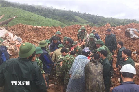 Các lực lượng đưa thi thể người bị nạn trong vụ sạt lở tại xã Hướng Phùng, huyện Hướng Hóa, tỉnh Quảng Trị ra bên ngoài. (Ảnh: TTXVN phát)