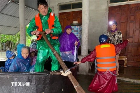Công an huyện Thạch Hà, tỉnh Hà Tĩnh cùng chính quyền địa phương hỗ trợ đưa người dân đi sơ tán. (Ảnh: TTXVN phát)