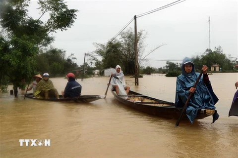 Người dân xã Quảng Phú, huyện Quảng Điền (Thừa Thiên-Huế) bị nước lũ 'bủa vây.' (Ảnh: Đỗ Trưởng/TTXVN)