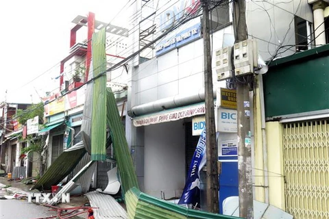 Bão số 9 với sức gió mạnh gây tốc mái nhà dân, giật tung nhiều biển quảng cáo trên đường phố Quảng Ngãi. (Ảnh: Lê Ngọc Phước/TTXVN)