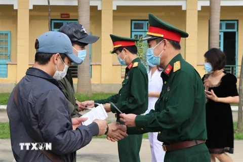 Lãnh đạo Bộ Chỉ huy quân sự tỉnh Hòa Bình trao giấy chứng nhận hoàn thành thời gian cách ly cho công dân. (Ảnh: Thanh Hải/TTXVN)