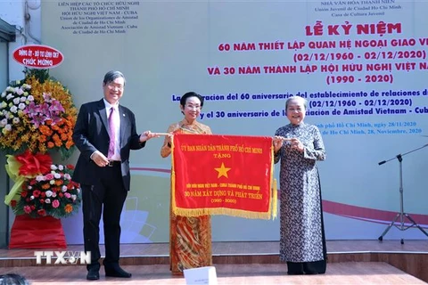 Ông Vương Đức Hoàng Quân, Chủ tịch Liên hiệp các tổ chức hữu nghị Thành phố Hồ Chí Min,h trao Cờ truyền thống của UBND Thành phố tặng Hội hữu nghị Việt Nam-Cuba Thành phố. (Ảnh: Xuân Khu/TTXVN)