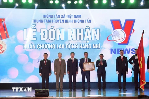 Tổng Giám đốc Thông tấn xã Việt Nam Nguyễn Đức Lợi trao Huân chương Lao động hạng Nhì của Chủ tịch nước tặng Trung tâm Truyền hình Thông tấn. (Ảnh: Phan Tuấn Anh/TTXVN)