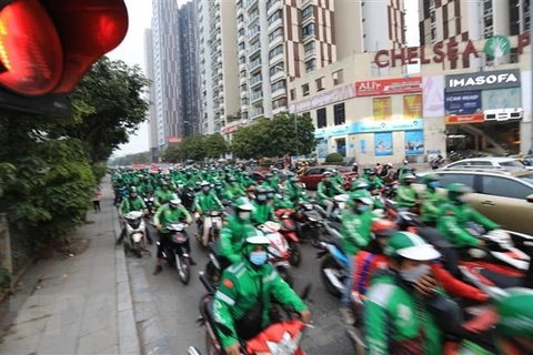 Hàng trăm tài xế Grab tập trung đông đảo diễu hành qua nhiều tuyến phố ở Hà Nội. (Ảnh: Thành Đạt/TTXVN)