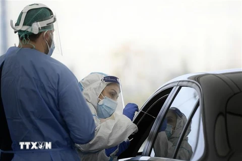 Nhân viên y tế lấy mẫu xét nghiệm COVID-19 tại Rome, Italy. (Ảnh: AFP/TTXVN)