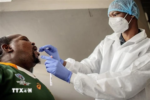  Nhân viên y tế lấy mẫu dịch xét nghiệm COVID-19 cho người dân tại Richmond, Johannesburg, Nam Phi, ngày 18/12/2020. (Ảnh: AFP/TTXVN)