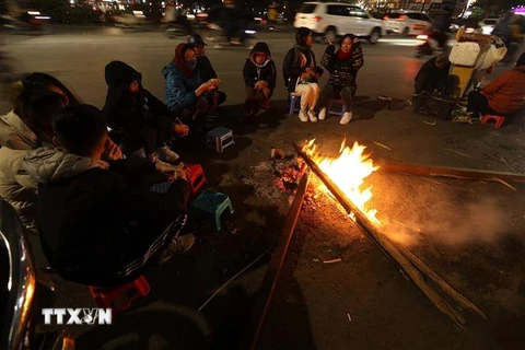 Nhiều người quây quần bên đống lửa để sưởi ấm. (Ảnh: Phan Tuấn Anh/TTXVN)