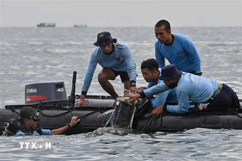 Thợ lặn thuộc các lực lượng hải quân tìm kiếm các mảnh vỡ chiếc máy bay gặp nạn tại vùng biển gần đảo Lancang, Indonesia, ngày 10/1. (Ảnh: AFP/TTXVN)