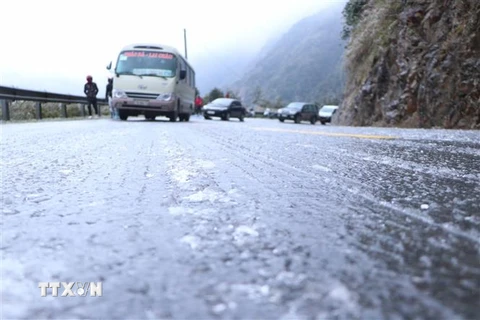 Băng phủ kín mặt đường đoạn đèo Ô Quy Hồ thuộc địa phận tỉnh Lai Châu đi Sa Pa khiến các phương tiện không thể lưu thông. (Ảnh: Nguyễn Oanh/TTXVN)