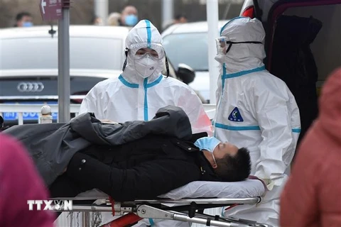 Nhân viên y tế chuyển một bệnh nhân nghi nhiễm COVID-19 tới bệnh viện ở Bắc Kinh, Trung Quốc, ngày 13/1/2021. (Ảnh: AFP/TTXVN)