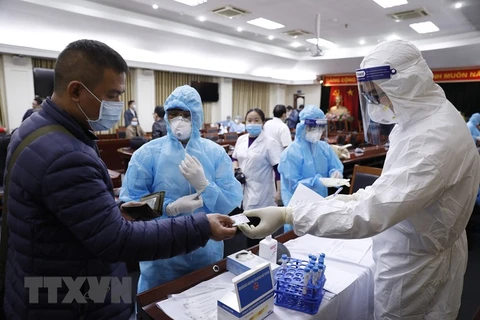 Làm thủ tục lấy mẫu xét nghiệm virus SARS-CoV-2 cho phóng viên tác nghiệp tại Đại hội XIII của Đảng. (Ảnh minh họa: Dương Giang/TTXVN)