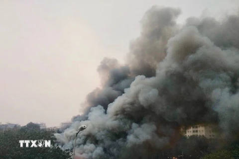 Đám cháy tạo ra cột khói đen bốc cao hàng chục mét. (Ảnh: Nguyễn Thắng/TTXVN)