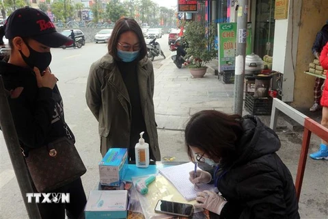 Người dân khai báo y tế trước khi vào chợ ở thành phố Hạ Long. (Ảnh: Đức Hiếu/TTXVN)