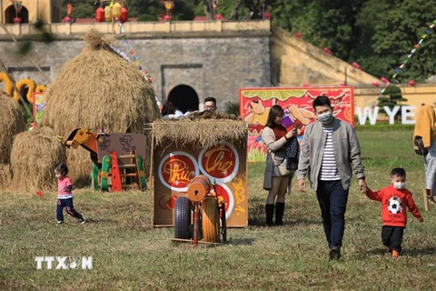 Du khách tham quan và trải nghiệm không khí Tết Việt xưa qua các trò chơi dân gian ở Hoàng thành Thăng Long. (Ảnh: Minh Đức/TTXVN)