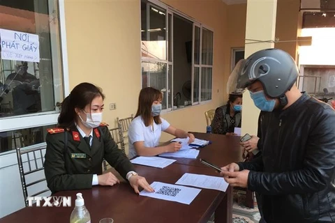 Lực lượng chức năng thành phố Hải Phòng hướng dẫn công dân khai báo y tế điện tử tại các chốt kiểm soát dịch bệnh COVID-19. (Ảnh: TTXVN phát)