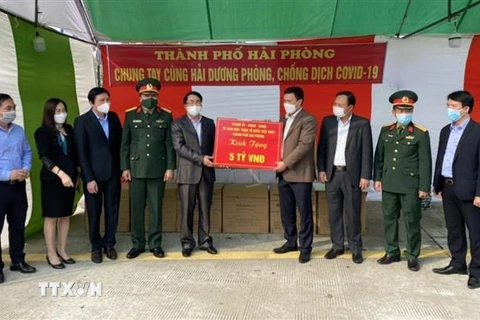 Phó Chủ tịch UBND thành phố Lê Khắc Nam cùng đoàn công tác của thành phố Hải Phòng trao tặng tỉnh Hải Dương số tiền 5 tỷ đồng. (Ảnh: TTXVN phát)