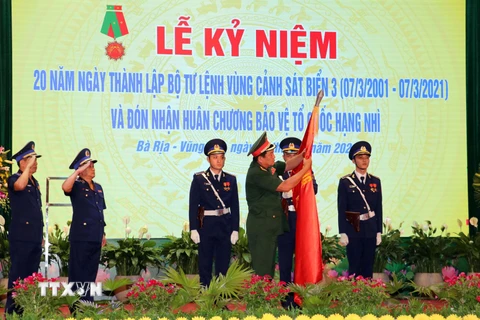 Thượng tướng Võ Minh Lương, Thứ trưởng Bộ Quốc phòng gắn Huân chương lên lá cờ truyền thống của Bộ Tư lệnh Vùng Cảnh sát biển 3. (Ảnh: Đoàn Mạnh Dương/TTXVN)