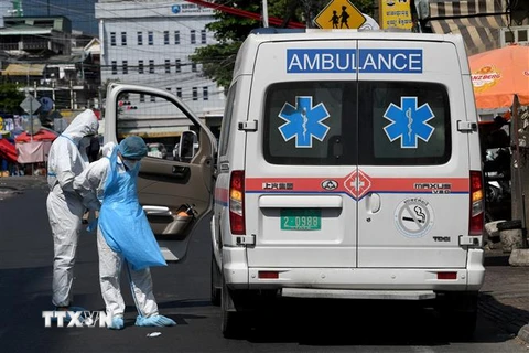  Nhân viên y tế và xe cứu thương được huy động để chuyển bệnh nhân COVID-19 tại Phnom Penh, Campuchia ngày 19/3/2021. (Ảnh: AFP/TTXVN)
