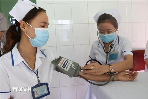 Kiểm tra sức khỏe cho nhân viên y tế trước khi tiêm vaccine phòng COVID-19. (Ảnh: Nguyễn Văn Trí/TTXVN)