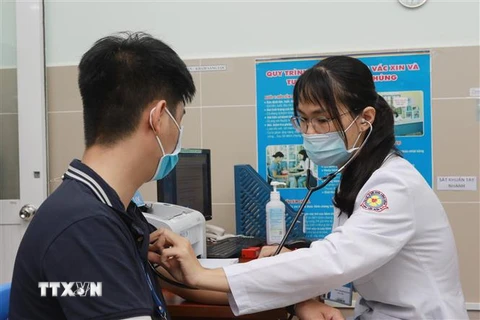 Nhân viên y tế Bệnh viện quận 11, TP.HCM được khám sàng lọc trước khi tiêm vaccine phòng COVID-19. (Ảnh: Đinh Hằng/TTXVN)