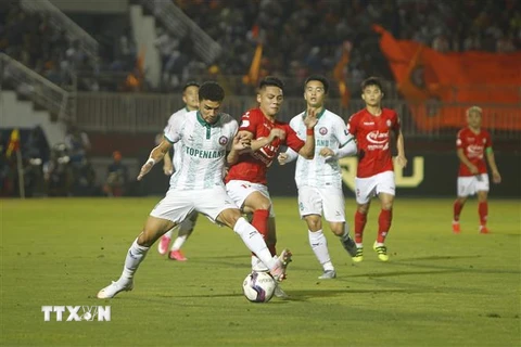 Pha tranh bóng giữa các cầu thủ giữa đội chủ nhà Thành phố Hồ Chí Minh (áo đỏ) và đội Bình Định (áo trắng). (Ảnh: Thanh Vũ/TTXVN)