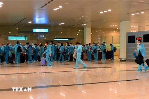 Công dân Việt Nam từ Đài Loan về nước được tiếp nhận, sắp xếp về khu cách ly y tế theo quy định. (Ảnh: TTXVN phát)