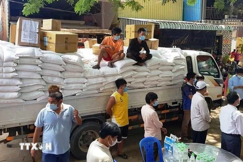 Bác sỹ và nhân viên y tế Bệnh viện Chợ Rẫy-Phnom Penh đã trích quỹ lương để mua ủng hộ 10 tấn gạo tặng cho 500 hộ gia đình trong đợt cứu trợ này. (Ảnh: Trần Ngọc Long/TTXVN)