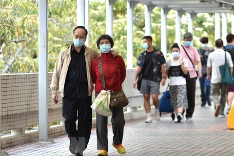 Người dân đeo khẩu trang phòng lây nhiễm COVID-19 tại Hong Kong,Trung Quốc. (Ảnh: THX/TTXVN)
