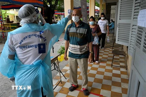 Kiểm tra thân nhiệt phòng lây nhiễm COVID-19 tại Phnom Penh, Campuchia. (Ảnh: AFP/TTXVN)