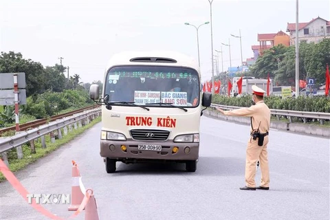 Lực cảnh sát giao thông số 8 Công an thành phố Hà Nội kiểm tra và xử lý các xe khách từ tỉnh ngoài vào Thủ đô tại km số 213, Quốc lộ 1A (huyện Phú Xuyên). (Ảnh: Phạm Kiên/TTXVN)