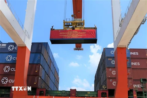 Container đầu tiên được vận chuyển lên tàu REN JIAN 25. (Ảnh: Huỳnh Ngọc Sơn/TTXVN)