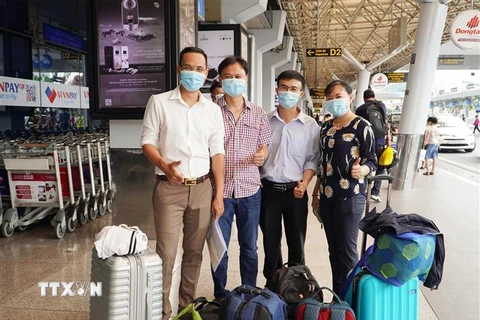 Đội phản ứng nhanh của Bệnh viện Chợ Rẫy chụp ảnh tại sân bay Tân Sơn Nhất trước khi ra Hà Nội hội quân cùng đoàn công tác Bộ Y tế để sang Lào hỗ trợ chống dịch. (Ảnh: TTXVN phát)