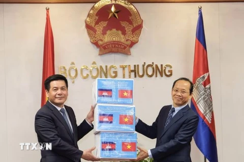 Bộ trưởng Công Thương Nguyễn Hồng Diên trao tượng trưng 20.000 khẩu trang phòng, chống dịch COVID-19 cho Đại sứ Campuchia. (Ảnh: Trần Việt/TTXVN)