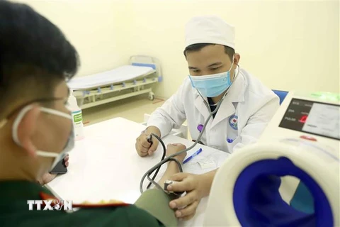 Thành viên Ban Chỉ đạo phòng chống COVID-19 thành phố Vĩnh Yên, tỉnh Vĩnh Phúc được kiểm tra sức khỏe trước khi tiêm vaccine phòng COVID-19. (Ảnh: Hoàng Hùng/TTXVN)