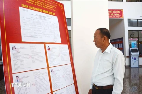 Cử tri phường Tự An, thành phố Buôn Ma Thuột, tỉnh Đắk Lắk xem danh sách và tiểu sử tóm tắt của những người ứng cử HĐND tỉnh khóa X. (Ảnh: Hoài Thu/TTXVN)