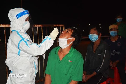 Nhân viên y tế lấy mẫu xét nghiệm cho người dân Cảng cá Thọ Quang. (Ảnh: Văn Dũng/TTXVN)