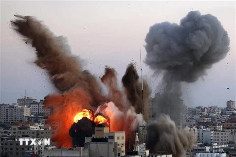Khói lửa bốc lên từ toà nhà có liên quan đến Phong trào Hamas của Palestine, sau khi trúng oanh tạc của máy bay Israel xuống Dải Gaza, ngày 14/5/2021. (Ảnh: AFP/TTXVN)