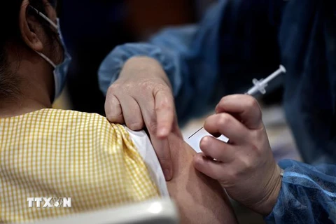 Nhân viên y tế tiêm vaccine ngừa COVID-19 của Pfizer-BioNTech cho người dân tại Paris, Pháp. (Ảnh: AFP/TTXVN)