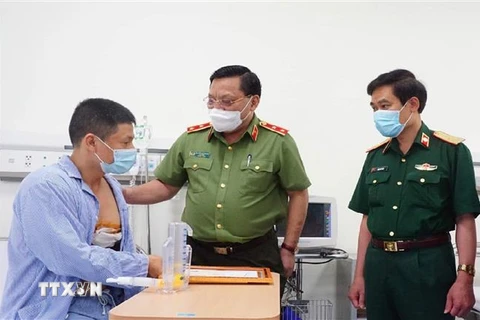 Trung tướng Nguyễn Hải Trung mong anh Nguyễn Trần Minh tiếp tục phát huy tinh thần dũng cảm, làm nhiều việc tốt hơn nữa, góp phần giữ gìn an ninh, trật tự. (Ảnh: TTXVN phát)