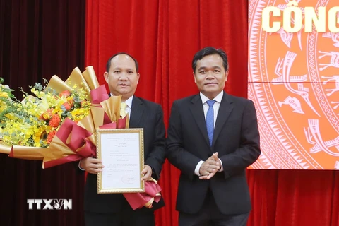 Ông Hồ Văn Niên (phải), Bí thư Tỉnh ủy Gia Lai, trao Quyết định, tặng hoa chúc mừng ông Rah Lan Chung. (Ảnh: Quang Thái-Đăng Vũ/TTXVN)
