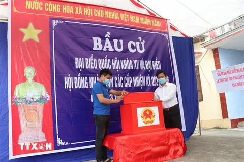 Thành viên tổ bầu cử số 3 đang hoàn tất các phần việc trang trí tại điểm bỏ phiếu đặt tại nhà ông Lê Văn Miên tại thôn Thúy Lâm, xã Thanh Sơn, huyện Thanh Hà. (Ảnh: Mạnh Minh/TTXVN)