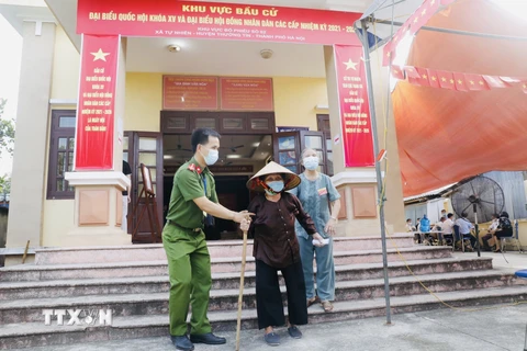 Các cử tri cao tuổi được giúp đỡ khi đi bầu cử tại điểm bầu cử xã Tự Nhiên, huyện Thường Tín, thành phố Hà Nội. (Ảnh: Trần Việt/TTXVN)